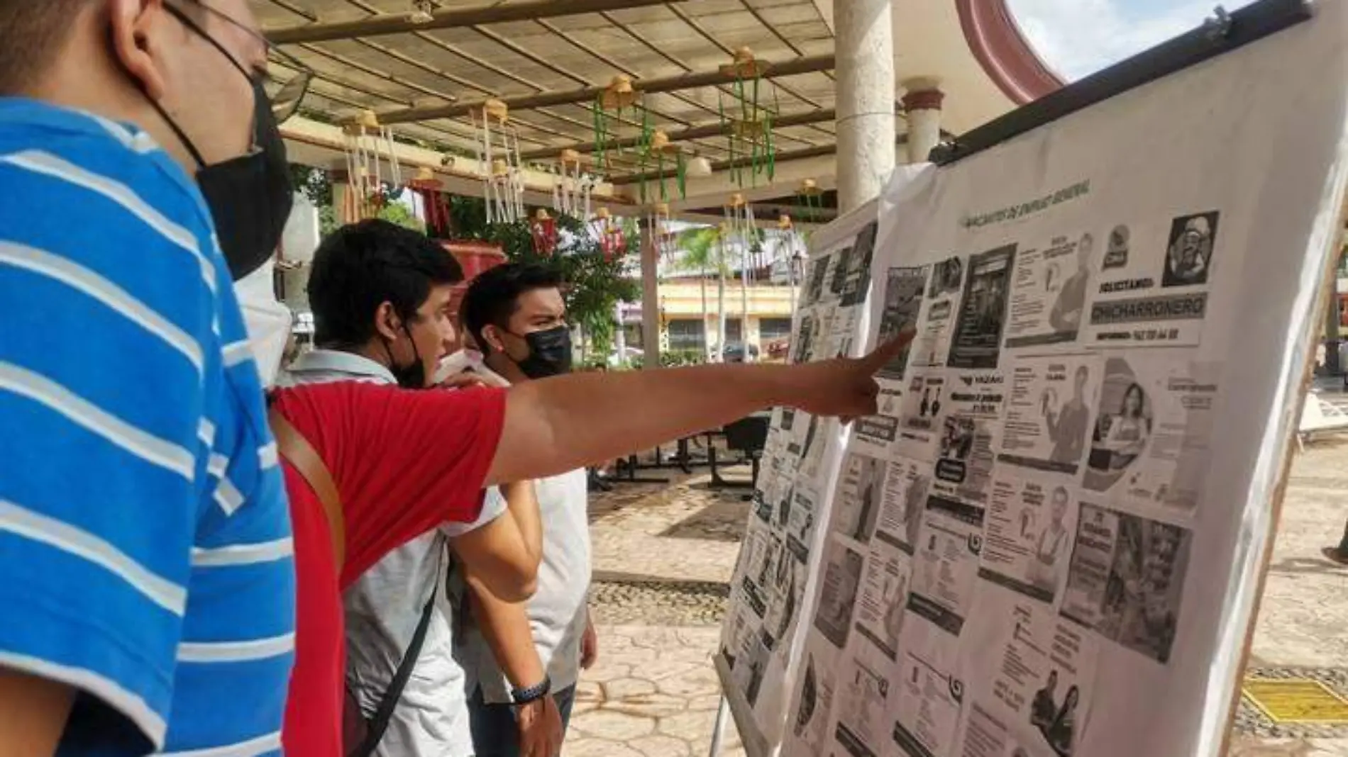 personas viendo cartel